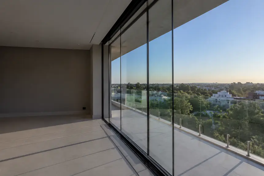 Sacada de apartamento fechada com cortina de vidro e vista para a cidade